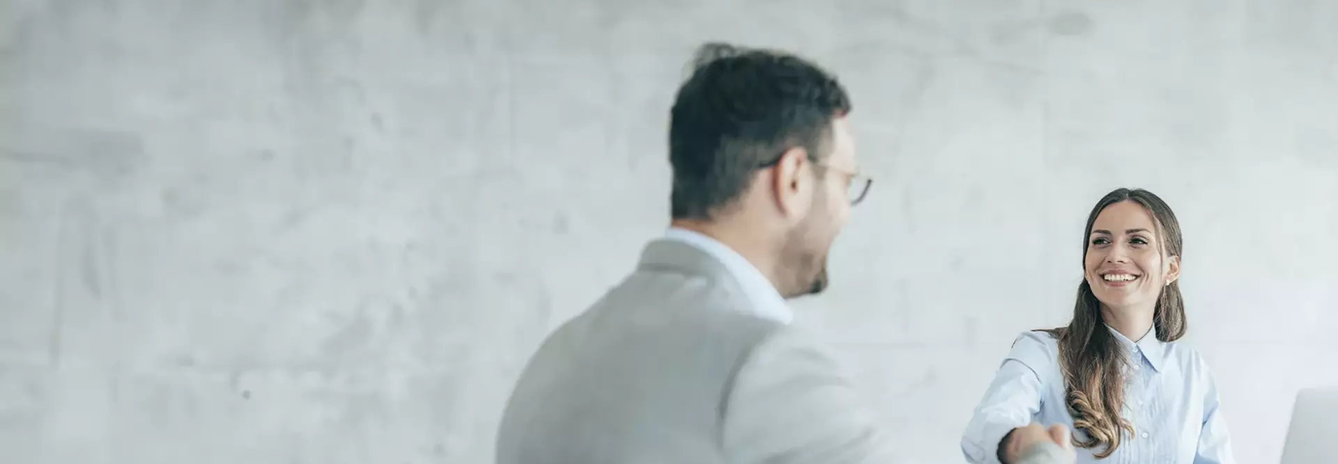 Una ragazza sorridente e un ragazzo si stringono la mano